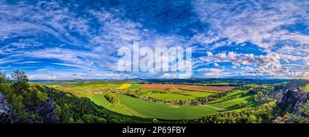 Paesaggio panoramico nel Parco Nazionale Sächsische Schweiz con paesaggio agricolo, il villaggio di Pabstdorf e formazioni rocciose. Foto Stock
