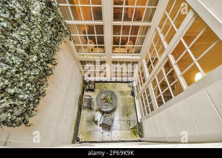 l'interno di un edificio con piante che crescono sulla parete e scale che portano al secondo piano, come si vede dall'alto Foto Stock