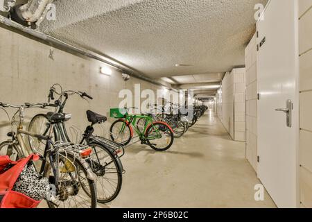 diverse biciclette parcheggiate in un garage con nessuno sulla bicicletta e altre due biciclette in piedi l'una accanto all'altra Foto Stock