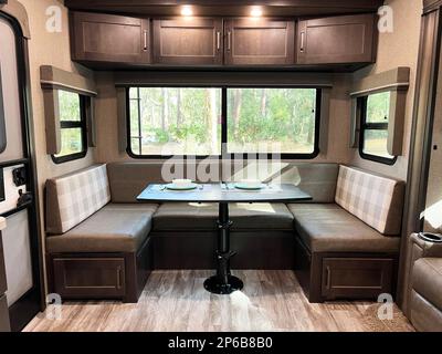 Perfetto per i lavori remoti, il design moderno e pulito di questo rimorchio da viaggio con ralla mostra la zona pranzo con un vano portaoggetti e un'enorme finestra panoramica. Foto Stock