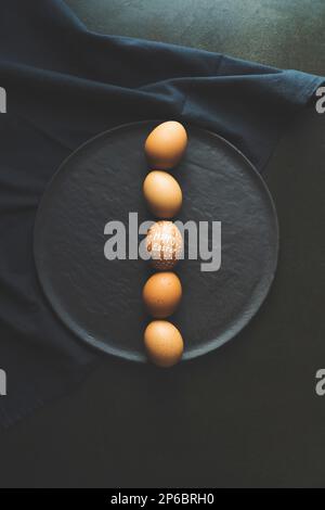 Happy easter Eggs dipinte a mano allineate in fila, vista dall'alto ripresa su sfondo nero Foto Stock