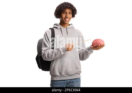 Studente maschio afro-americano in possesso di un cervello umano e puntando con un bastone isolato su sfondo bianco Foto Stock