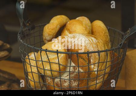Prodotti da forno a base di pasta madre appena sfornata con crosta dorata sugli scaffali dei prodotti da forno. Panetteria contesto con delizioso pane. Foto Stock