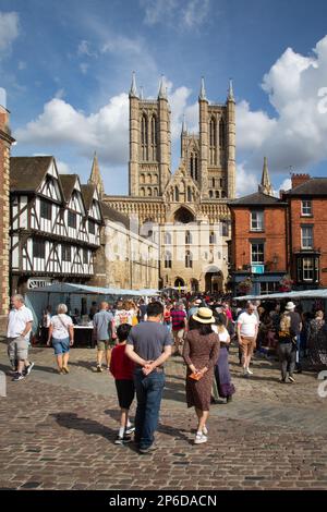 I turisti che camminano attraverso Castle Hill, Exchequer Gate e Lincoln Cathedral possono essere visti sullo sfondo. Foto Stock