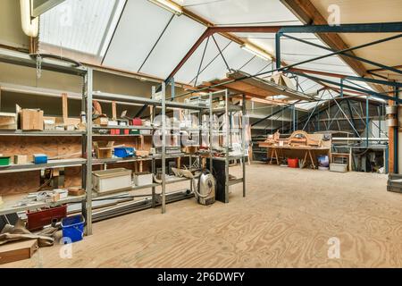 l'interno di un edificio che viene utilizzato come officina per la lavorazione del legno e altre cose su cui lavorare Foto Stock