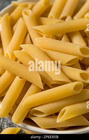 Mostaccioli Penne lisce crudo secco Pasta in una ciotola Foto Stock