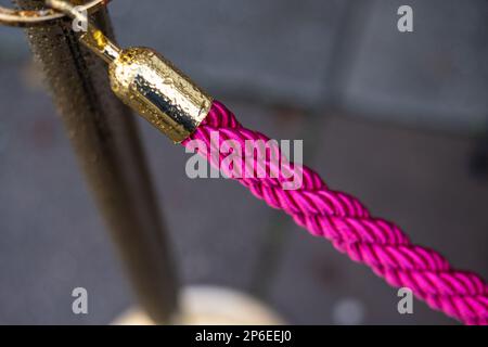 Corda rosa brillante su un palo d'oro Foto Stock