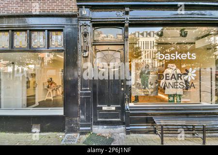 Amsterdam, Paesi Bassi - 10 Aprile, 2021: Una vetrina con un orologio sul davanti e un annuncio nella finestra che dice il caffè di Basi Foto Stock