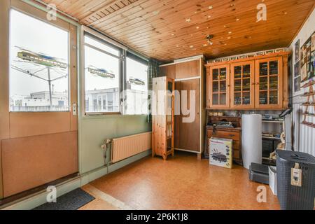 all'interno di una vecchia casa con pareti rivestite in legno e pavimenti in legno all'esterno, c'è un frigorifero nel Foto Stock