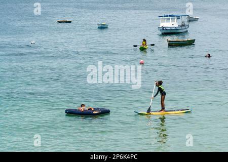 Salvador, Bahia, Brasile - 14 gennaio 2022: La gente si diverte a fare una passeggiata a nuoto stand-up sulla spiaggia di Porto da barra a Salvador, Bahia. Foto Stock