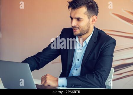 Bell'uomo d'ufficio sorridente barbuto con la penna d'argento in braccio fa il ritratto della carta. Foto Stock