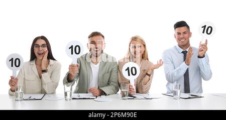 Gruppo di giudici con i segni con il punteggio più alto a tavola su sfondo bianco Foto Stock