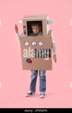 Bambino in costume robot di cartone su sfondo rosa Foto Stock