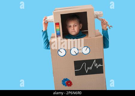 Bambino in costume robot di cartone su sfondo blu Foto Stock