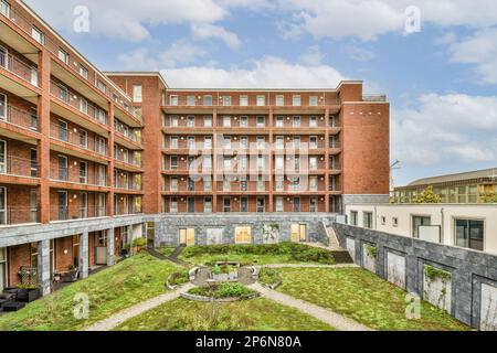 Amsterdam, Paesi Bassi - 10 aprile 2021: Una zona esterna con erba sul terreno e alcuni edifici sullo sfondo che sono di colore rosso, ma nessuno è visibile Foto Stock