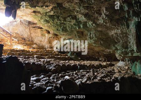 Fotografia della Grotta di Rangko in pietra calcarea a Labuan Bajo su Flores con stalattiti dal soffitto e il sole che splende nella grotta. Foto Stock