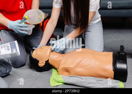 Donna che tiene il sacchetto di respirazione Ambu bag.dimostrazione CPR Cardiopolmonare rianimazione procedura medica di formazione sulla bambola CPR nella classe.Paramedic dem Foto Stock