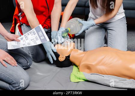 Donna che tiene il sacchetto di respirazione Ambu bag.dimostrazione CPR Cardiopolmonare rianimazione procedura medica di formazione sulla bambola CPR nella classe.Paramedic dem Foto Stock