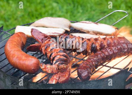 Salsicce e pancetta alla griglia Foto Stock