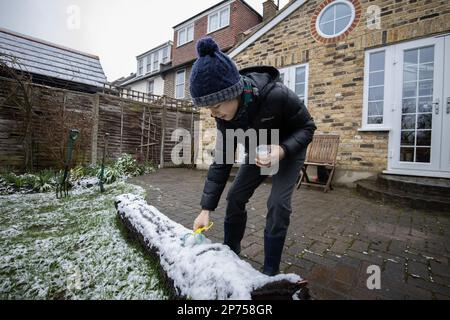 Londra, Inghilterra, Regno Unito 8th marzo 2023, Un giovane ragazzo che raccoglie la neve dopo un dondolamento di neve durante le temperature meno nelle prime ore di questa mattina causa le docce di neve attraverso la Grande Londra, Inghilterra, Regno Unito 8th marzo 2023 Londra, Inghilterra, Regno Unito Foto Stock