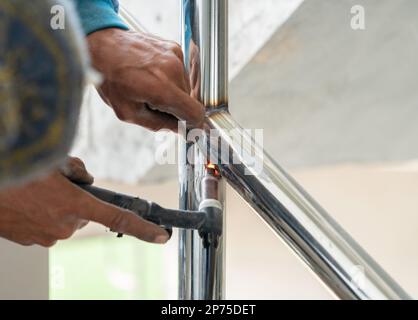 Primo piano della rotaia di saldatura dell'operatore nel cantiere. Foto Stock