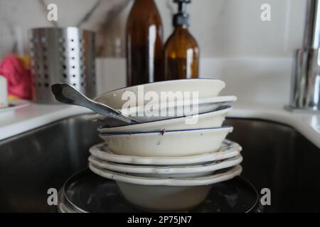 Piatti sporchi nel lavandino. Nel lavello sono presenti piastre sporche e una teglia. Foto Stock