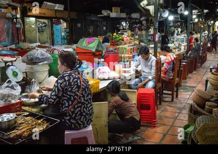 Popolo cambogiano seduto presso bancarelle alimentari all'interno del mercato russo a Phnom Penh, Cambogia. Foto Stock