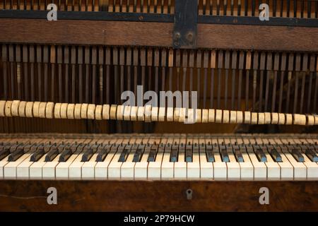 Vecchie parti esposte al pianoforte non riproducibili rotte, vista frontale dello stato fatiscente. Foto Stock