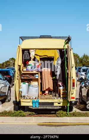 Un camper giallo con donna affollata all'interno parcheggiata in un affollato parcheggio in Portogallo Foto Stock