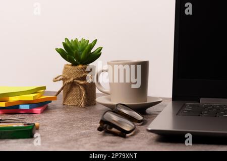 Scrivania da ufficio con computer portatile e altre attrezzature da lavoro con tazza da caffè. con spazio di copia per l'immissione di testo Foto Stock