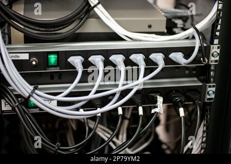 Collegamento disordinato dei cavi di alimentazione del computer e della LAN. primo piano non ha girato persone Foto Stock