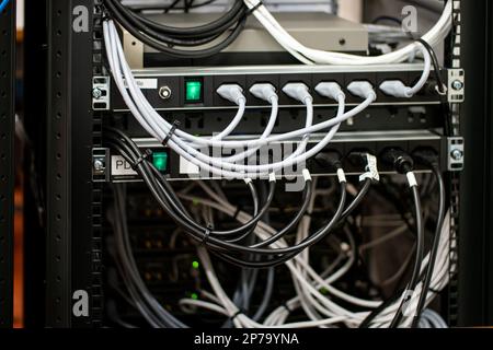 Collegamento disordinato dei cavi di alimentazione del computer e della LAN. primo piano non ha girato persone Foto Stock