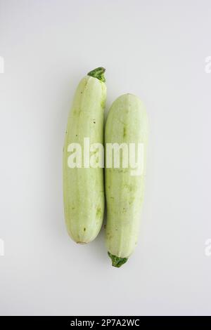 Due Zucchinis freschi grezzi vicini insieme vista dall'alto studio girato isolato su bianco. Foto Stock