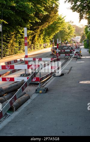 Cantiere di ristrutturazione stradale in una strada in Europa con barricate e deviazioni. Non c'è luce al tramonto. Foto Stock