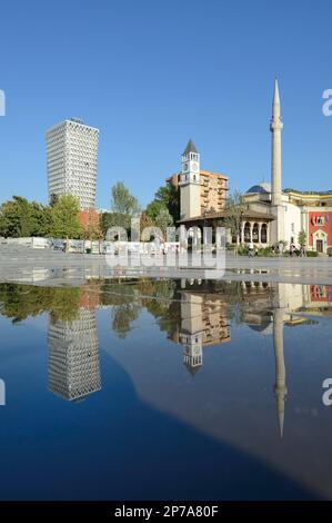 Plaza Hotel, il Campanile e la Moschea di Ethem Bey si riflettono in una pozza, Piazza Skanderbeg, Tirana, Albania Foto Stock