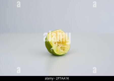 Spremuto fresco verde dimezzato lime primo piano isolato su bianco. Foto Stock