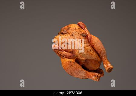 Pollo fresco intero, crudo e pronto condito. Primo piano ripresa in studio, isolata su sfondo marrone. Foto Stock