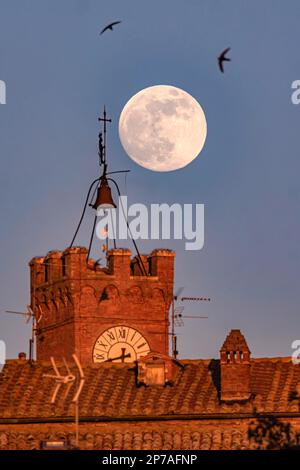 Luna piena su Pienza in Toscana di fronte alla storica torre del municipio con orologio, Palazzo pubblico, Pienza, provincia di Siena, Italia Foto Stock