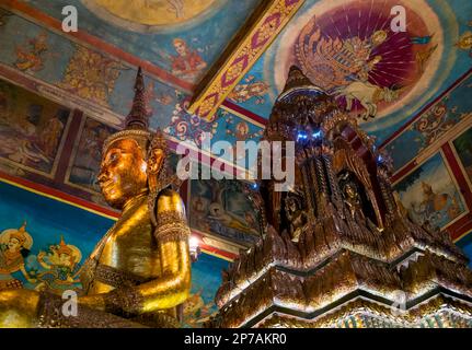 Una statua di Buddha all'interno dell'alter principale presso l'antico wat Phnom buddista a Phnom Penh, Cambogia. Foto Stock