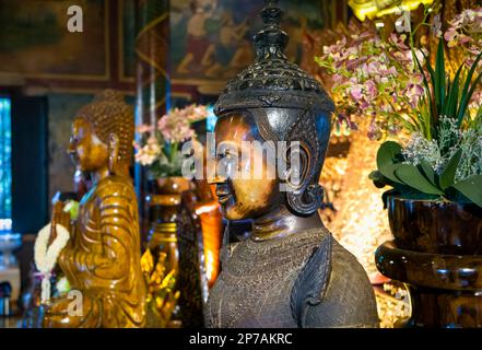 Statue all'interno della principale altera presso l'antico wat Phnom buddista a Phnom Penh, Cambogia. Foto Stock