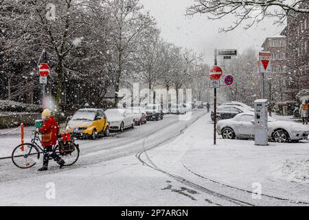 Neve soffiata a Düsseldorf, ciclista su strade innevate Foto Stock