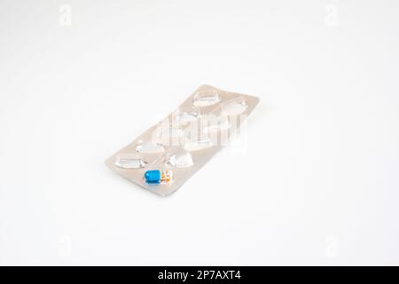 Ultima pillola capsula medica colorata in una confezione blister usata. Primo piano ripresa in studio, isolata su sfondo bianco. Foto Stock