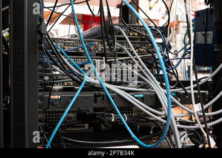 Molti cavi che collegano vari dispositivi elettronici all'interno del laboratorio scientifico. Primo piano, nessuna gente. Foto Stock