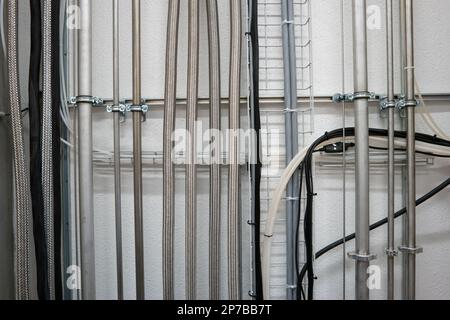 Tubi industriali in alluminio inox verticali montati a parete. Foto Stock