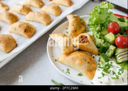 Empanadas con macinato di manzo, ripieno di formaggio e insalata di contorno Foto Stock