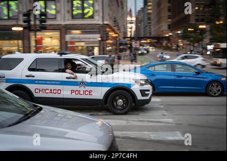 Poliziotto di Chicago che guida una macchina di pattuglia sulla strada in servizio Foto Stock