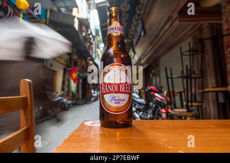 Una bottiglia di birra Hanoi su un tavolo in una strada sul retro di Hanoi, Vietnam. Foto Stock