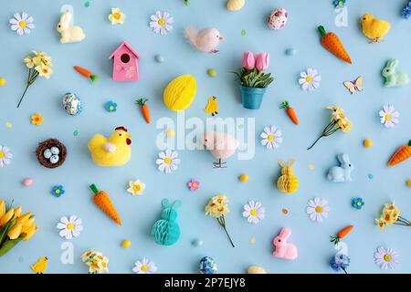 Sfondo collezione di oggetti di Pasqua disposti su uno sfondo blu, vista dall'alto Foto Stock