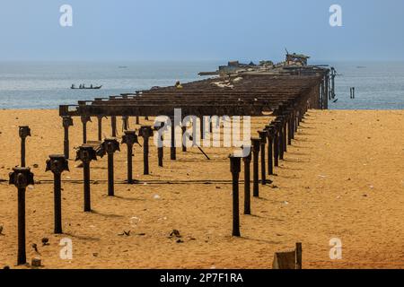 una fila di sostegni metallici sulla spiaggia sabbiosa di lome che conducono all'oceano atlantico fanno parte del vecchio molo, ormai abbandonato Foto Stock