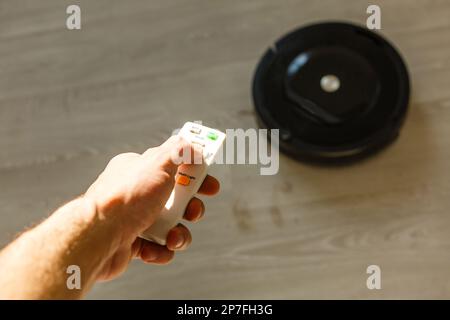 Romanticismo a controllo manuale del vuoto robotizzato su pavimenti in laminato di legno. Foto Stock